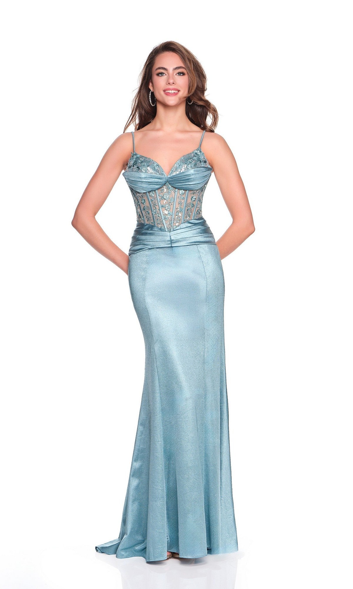 A woman poses in the Dave and Johnny 12426 long prom dress—light blue, floor-length, sleeveless, with an embellished corset bodice and a satin sheath skirt—against a plain white background.
